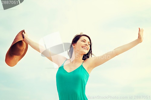 Image of girl in hat standing on the beach