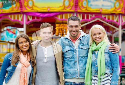 Image of group of smiling friends in amusement park