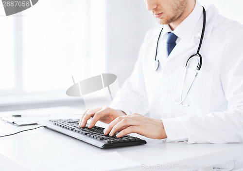 Image of male doctor typing  on the keyboard