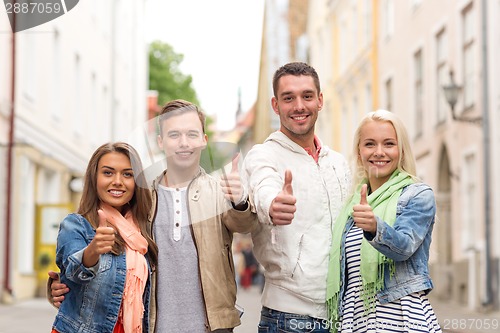 Image of group of smiling friends showing thumbs up