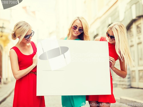 Image of three happy blonde women with blank white board