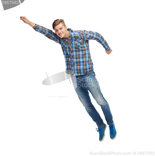 Image of smiling young man flying in air