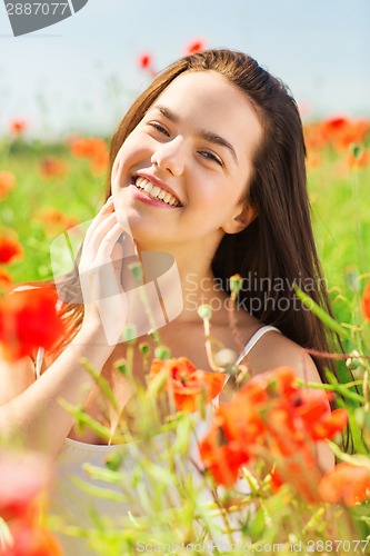 Image of smiling young woman on poppy field