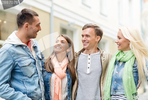 Image of group of smiling friends walking in the city