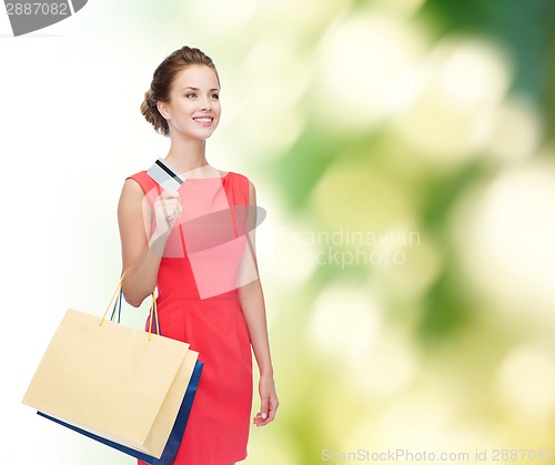 Image of smiling woman with shopping bags and plastic card