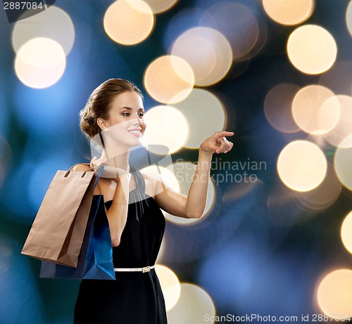 Image of smiling woman in dress with shopping bags