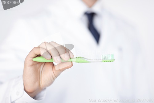 Image of dentist or stomatologist holding toothbrush