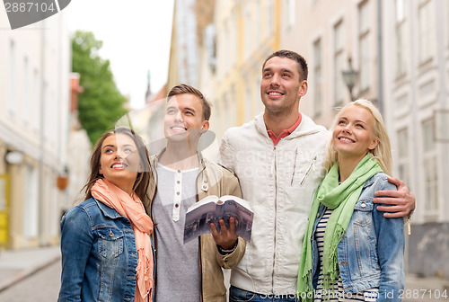 Image of group of friends with city guide exploring town