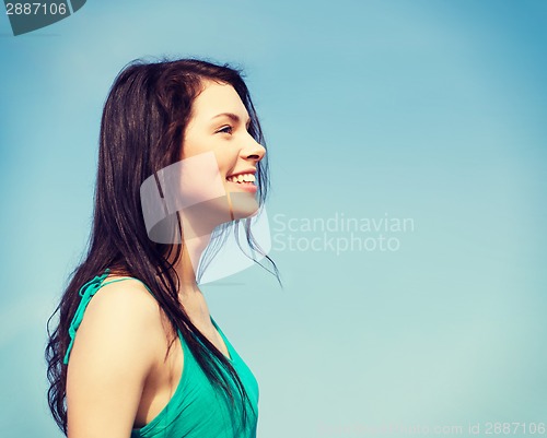 Image of beautiful girl over blue sky