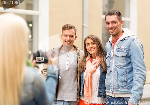 Image of group of smiling friends taking photo outdoors