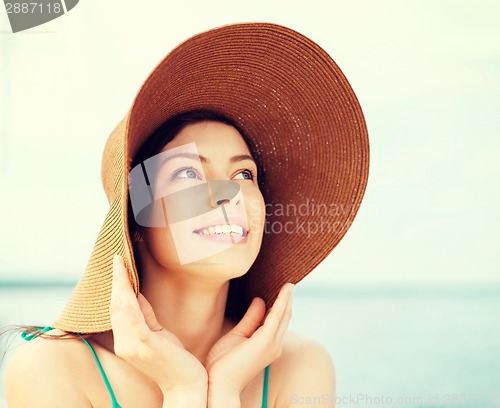 Image of girl in hat standing on the beach