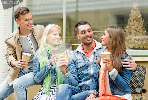 Image of group of smiling friends with take away coffee