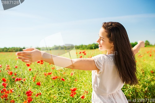 Image of smiling young woman on poppy field