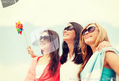 Image of smiling girls in shades having fun on the beach