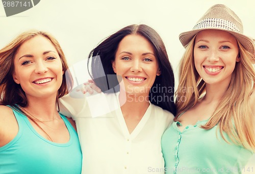 Image of group of smiling girls chilling on the beach
