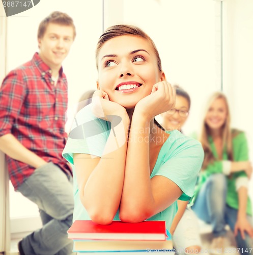 Image of happy smiling student girl with books at school