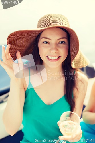 Image of smiling girl in hat with champagne glass