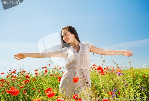 Image of smiling young woman on poppy field