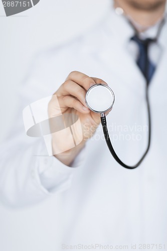 Image of doctor hand with stethoscope listening something