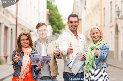 Image of group of smiling friends with city guide and map