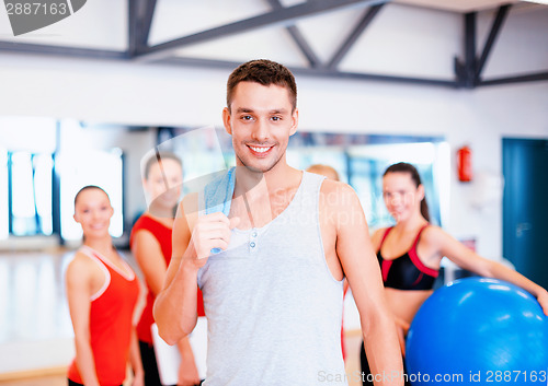 Image of smiling man standing in front of the group in gym