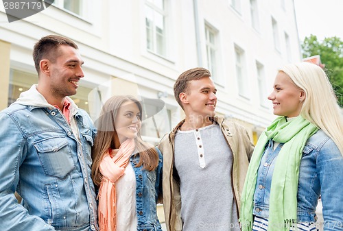 Image of group of smiling friends walking in the city
