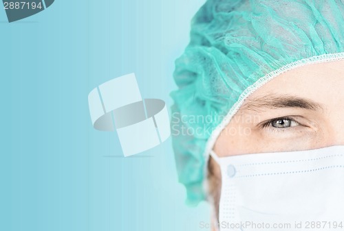 Image of surgeon in medical cap and mask