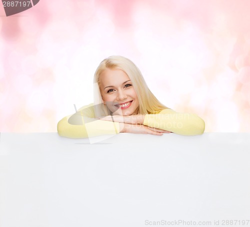 Image of smiling woman in sweater with blank white board