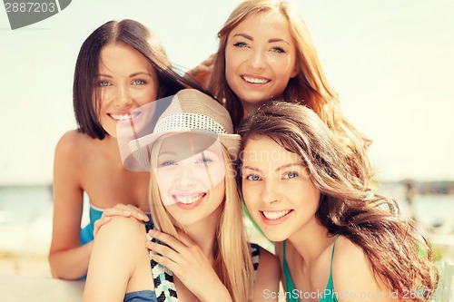 Image of group of smiling girls in cafe on the beach