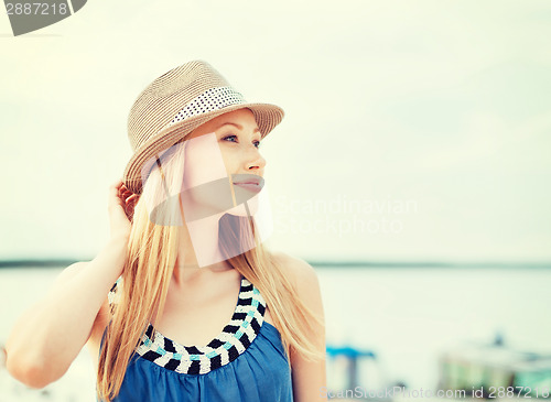 Image of girl in hat standing on the beach