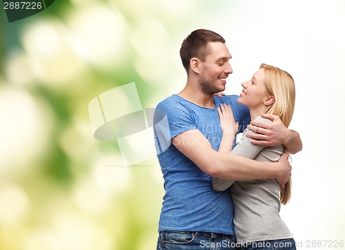 Image of smiling couple hugging and looking at each other