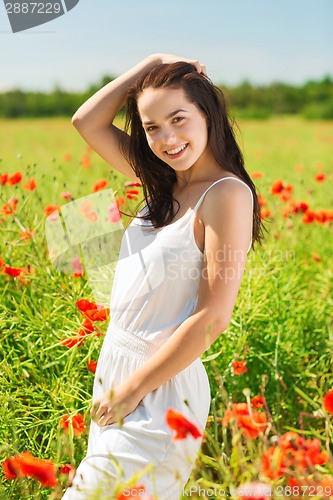 Image of smiling young woman on poppy field