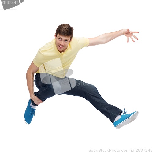 Image of smiling young man jumping in air