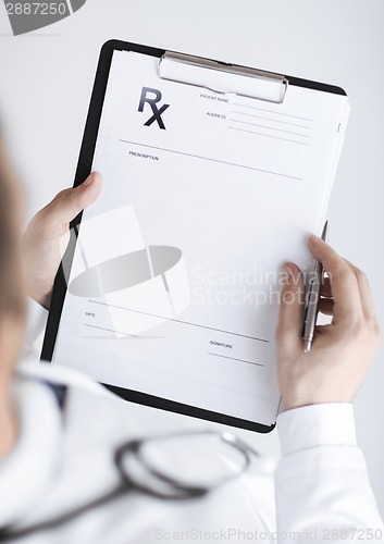 Image of male doctor writing prescription paper