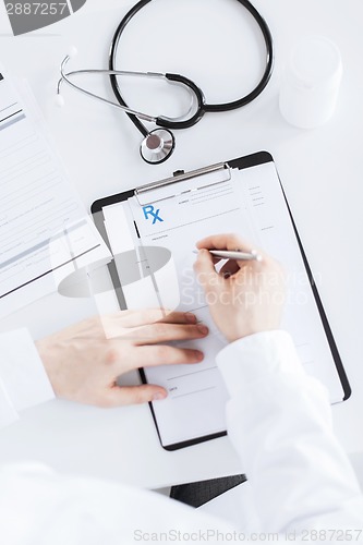 Image of male doctor writing prescription paper