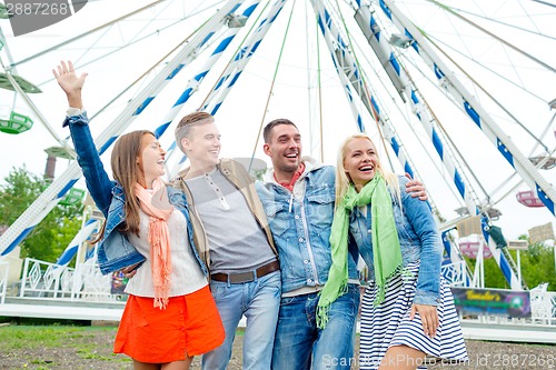 Image of group of smiling friends waving hands