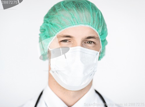 Image of surgeon in medical cap and mask