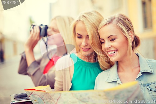 Image of beautiful blonde women with map in the city