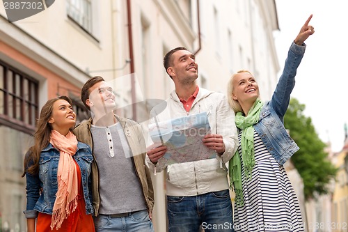 Image of group of smiling friends with map exploring city