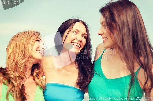 Image of smiling girls walking on the beach