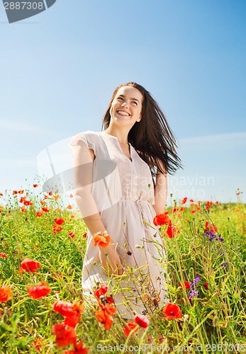 Image of smiling young woman on poppy field