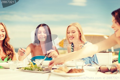 Image of smiling girls in cafe on the beach