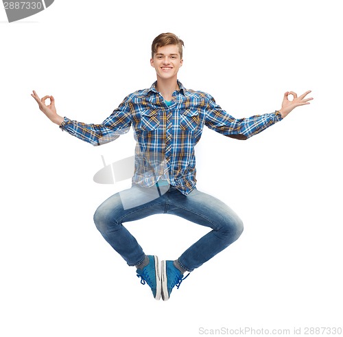 Image of smiling young man flying in air