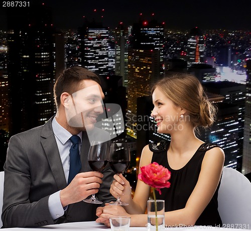 Image of young couple with glasses of wine at restaurant