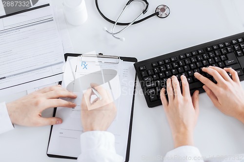 Image of doctor and nurse writing prescription paper