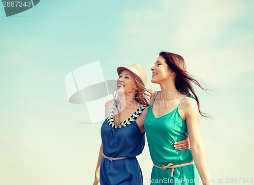 Image of smiling girls walking on the beach