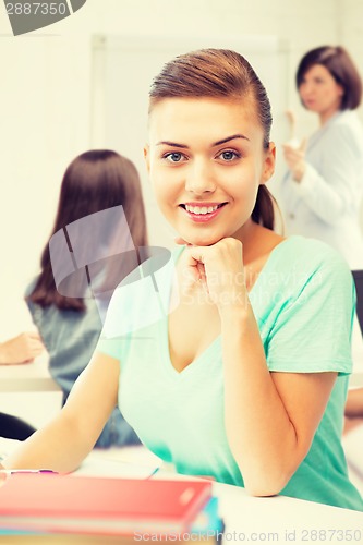 Image of happy smiling student girl with books at school