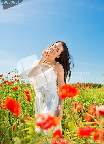 Image of smiling young woman on poppy field