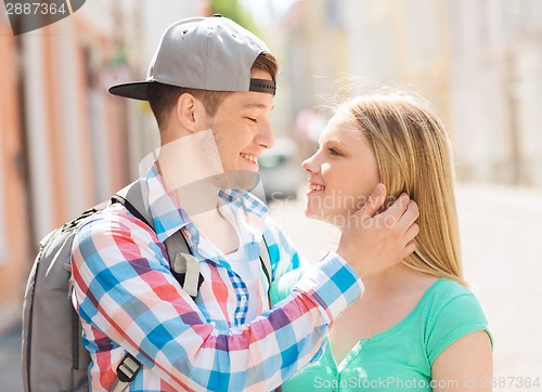 Image of smiling couple with backpack in city