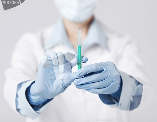 Image of female doctor holding syringe with injection